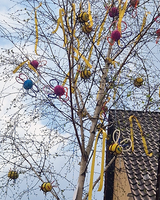 selbst gebastelte Bienen und bunte Blumen, die nun am ersten Osterbaum in der Nähe des Lippegartens hängen.